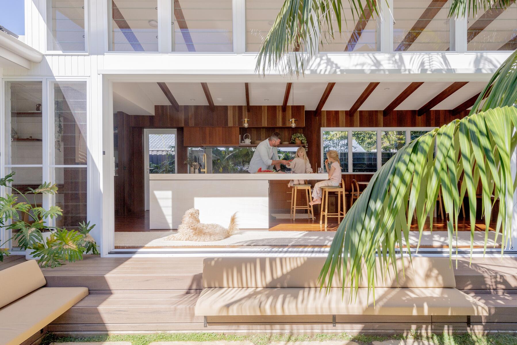 Family in an open-plan Townsville home opening onto a deck